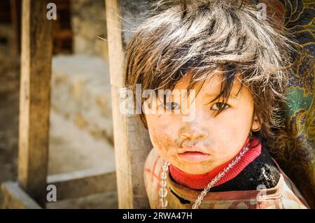 Kanchenjunga Trek, Nepal, um Mai 2012: Foto eines kleinen braunhaarigen Mädchens in rosa Hemd mit Schmutz im Gesicht und mit Kette aus Perlen in Stockfoto