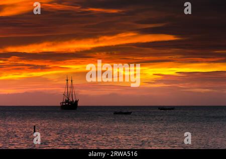 Das Bild zeigt die Goldene Stunde mit Segelbooten auf dem Meer, die vor dem Sonnenuntergang ankern. Das Bild wurde in Aruba, im Karibischen Meer, aufgenommen Stockfoto