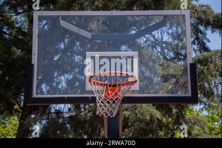 Basketballfeld im Freien, orangefarbener Basketballkorb, Netz und Rückwand für Basketballspiele im Schulgarten. Türkei, Istanbul Stockfoto