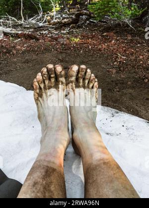 Dreckige Füße einer weiblichen Rucksacktouristin Stockfoto