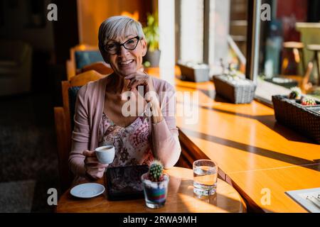 Die reife Frau sitzt im Café und entspannt sich. Stockfoto