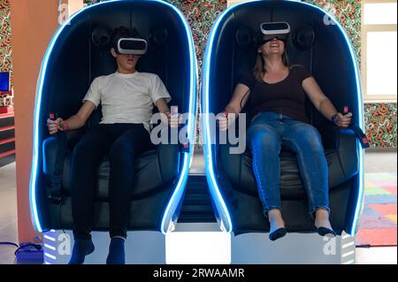 Virtual-Reality-Attraktion: Sohn und Mutter erleben Adrenalin aus Virtual-Reality-5D-Sensation. Stockfoto