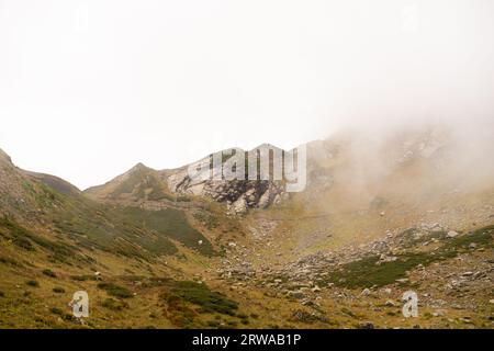 Bergkette mit sichtbaren Silhouetten durch den Morgennebel. Stockfoto