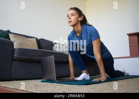 Frau, die zu Hause Sport macht, Bewegungsübungen macht, Dehnübungen Stockfoto