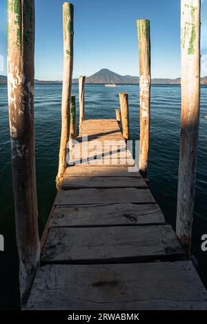 Hölzerne Anlegestelle am Atitlan-See am Strand in Panajachel, Guatemala. Mit Toliman und San Pedro Vulkanen im Hintergrund. Eine wunderschöne Bucht mit Seeblick Stockfoto