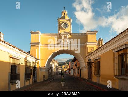 Der berühmte Bogen von Santa Catalina in der Innenstadt von Antigua, Guatemala, und ein Blick auf den Vulkan von Agua dahinter Stockfoto