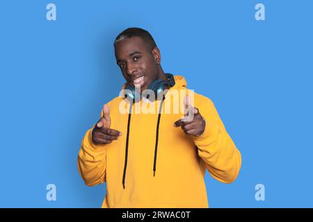 Du bist der nächste. Fröhlicher Afroamerikanischer Millennials-Mann, Der Mit Den Fingern Auf Die Kamera Zeigt Und Sie Im Studio Über Blauem Hintergrund Wählt. Hell Stockfoto