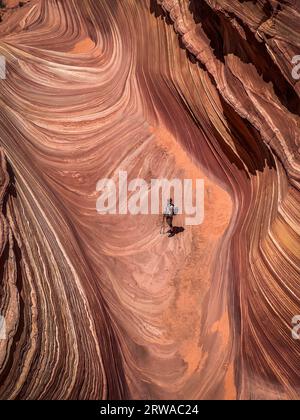 Ein einsamer männlicher Wanderer in der berühmten Welle in North Coyote Buttes Stockfoto