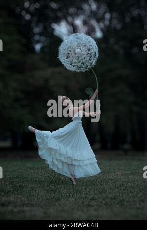 Wunderschöne Ballerina mit riesigen Löwenzahn-Blüten Stockfoto