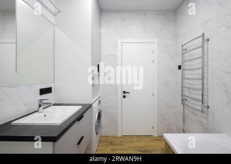 Wasserhahn mit Keramikwaschbecken und Badewanne im Badezimmer Stockfoto