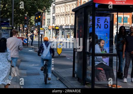 Radweg-Autobahn neben einer Bushaltestelle in Aldgate/Whitechapel am 16. August 2023 in London, Vereinigtes Königreich. Ein Radweg Superhighway ist ein langer Radweg und Teil des vom TfL koordinierten Radwegenetzes. Es ist eine beliebte Strecke sowohl für Pendler als auch für Freizeitradler, die entlang der Strecke an einer Reihe wichtiger Ziele in London vorbeiführt. Für fast die gesamte Strecke sind Radfahrer auf getrennten Radwegen vom anderen Verkehr getrennt, und an wichtigen Knotenpunkten wurde eine Radfahrinfrastruktur bereitgestellt. Stockfoto