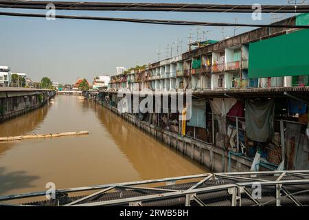 Kanal mit einer Reihe von alten Häusern am Wasser in Bangkok, Thailand. Stockfoto