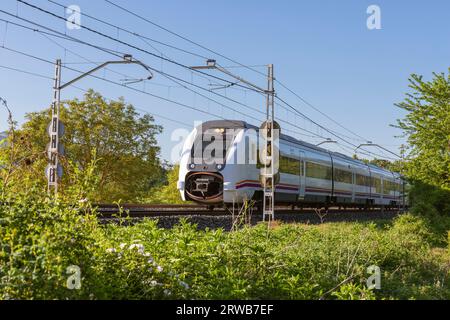 Europa, Spanien, Baskenland, Arminon, New Renfe Mittelstrecken-Elektropersonenzug fährt in der Nähe des Dorfes vorbei Stockfoto