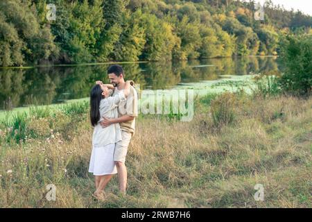 Glücklicher Mann und Frau in der Natur am Fluss, die sich gegenseitig genießen. Stockfoto