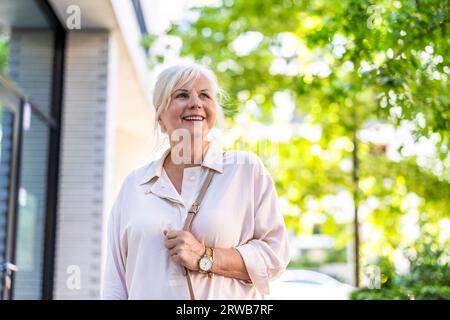 Porträt einer glücklichen Seniorin, die in der Stadt steht Stockfoto