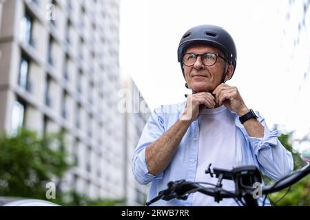 Reifer Mann, der vor dem Radfahren in der Stadt Helm trägt Stockfoto