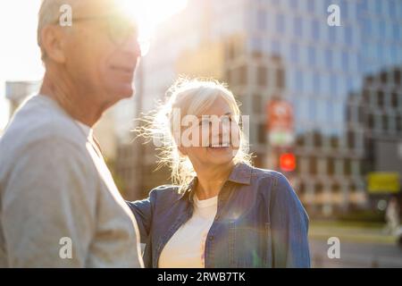 Porträt eines glücklichen älteren Paares, das an einem sonnigen Tag in der Straße der Stadt steht Stockfoto