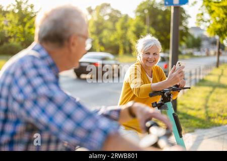 Ein älteres Paar, das in der Stadt Elektroroller fährt Stockfoto