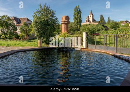 Hunawihr, Frankreich - 09 04 2023: Blick auf den Brunnen Sainte-Hune mit der Gemischten Kirche Saint-Jacques-le-Majeur im Hintergrund Stockfoto