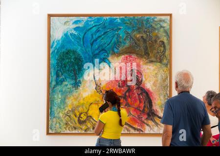 Touristen/Besucher sehen Marc Chagalls Gemälde „Le Sacrifice d' Isaac“ / „das Opfer von Isaac“ im Musée National Marc Chagall. Schön. Stockfoto