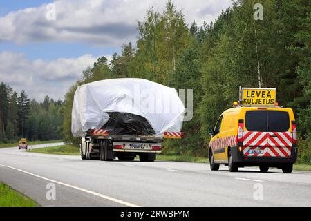 Lkw transportiert Überlast auf Tieflader in Richtung Hafen Hanko. Der Transport verfügt über Pilotfahrzeuge vorn und hinten. Raasepori, Finnland. September 23 Stockfoto