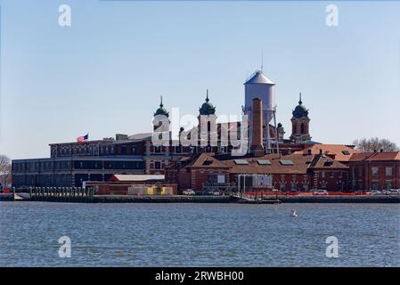 Ellis Island vom Liberty State Park, New Jersey aus gesehen: Gepäckgebäude und Schlafsaal befinden sich links vom viertürmigen Hauptgebäude (Museum). Stockfoto