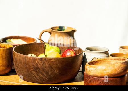Mittelalterliche Nachstellung, ein Tisch mit Obst und Getränken vor einem weißen Hintergrund. Holzschale mit Äpfeln und Birnen, verschiedene andere Tassen und Schüsseln Stockfoto