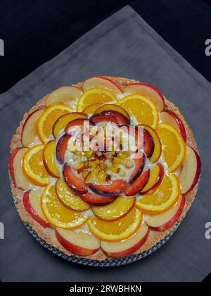 Ein Stück Pfirsichtorte mit frischen Früchten auf einem Holztisch, Blick von oben Stockfoto