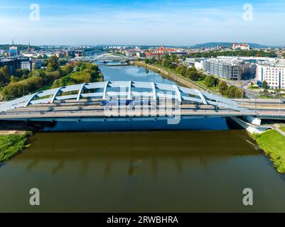 Krakau, Polen. Hängebrücke Kotlarski mit Stadtautobahn, Radweg, Straßenbahn und einer blauen Straßenbahn über die Weichsel. Andere Brücken und Altstadt mit Stockfoto