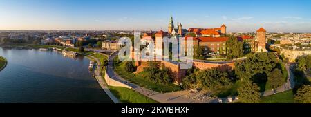 Krakau, Polen. Breites Luftpanorama der Altstadt bei Sonnenuntergang mit Royal Wawel Schloss und Kathedrale. Flussufer der Weichsel, Touristenboote, Häfen, Parks, Stockfoto