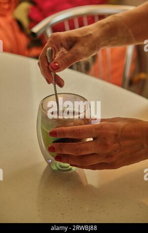 Frau gießt heißen Kaffee in der Tasse am Morgen aus der Kanne. Hausfrau zu Hause, die frisch gemahlenen Kaffee in der Küche zum Frühstück, Trinken, Schleifen koff Stockfoto