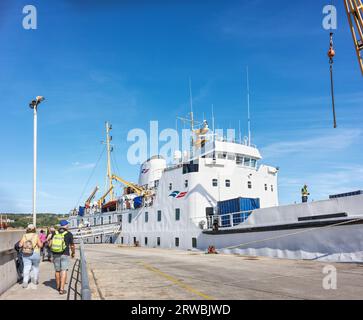 Passagiere auf dem Weg an Bord der Scillonian III Fähre, die am Kai im Hafen von St. Mary's, Isles of Scilly, anlegt. Stockfoto