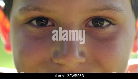 Kindergesicht-Close-up-Augenschließen in der Meditation. Junge, der Augen öffnet, lächelt vor der Kamera, Makroaufnahme Stockfoto