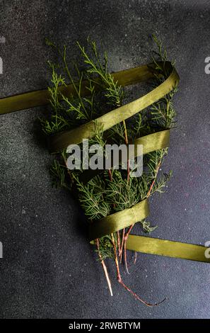 Blick von oben auf grüne Tannenzweige, die als Symbol der Weihnachtsfeier mit einem Band verziert sind Stockfoto