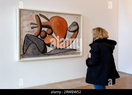 Person im Musée national Picasso-Paris mit Blick auf das Gemälde Femme lancant une pierre von Pablo Picasso (Woman Throwing a Stone, Paris, 8. März 1931). Stockfoto