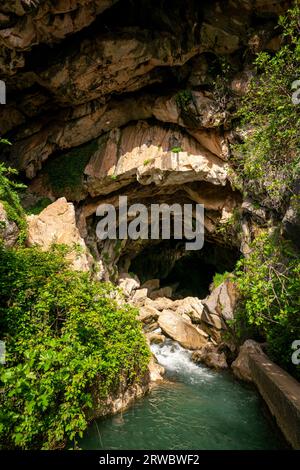 Von oben durchsichtiges, klares, plätscherndes Flusswasser, das durch die felsige Grotte Cueva del gato inBenaoján in Malaga, Spanien, fließt Stockfoto