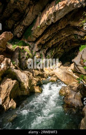 Von oben durchsichtiges, klares, plätscherndes Flusswasser, das durch die felsige Grotte Cueva del gato inBenaoján in Malaga, Spanien, fließt Stockfoto