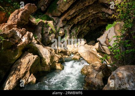 Von oben durchsichtiges, klares, plätscherndes Flusswasser, das durch die felsige Grotte Cueva del gato inBenaoján in Malaga, Spanien, fließt Stockfoto