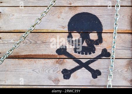 Holzkiste mit gemaltem Schädel und Kreuzknochen. Gefährliche Fracht. Stockfoto