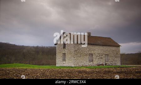 Das historische Steinhaus „Lockkeeper's House“ wurde 1845 an einem bewölkten und Reifen Frühlingstag in Iowa erbaut. Stockfoto