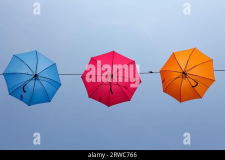 Sonnenschirme hängen an einem Seil, das von unten fotografiert wurde Stockfoto