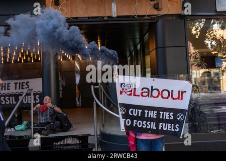 Mitglieder der Extinction Rebellion Poor Oil On, Ketten sich an und klettern den Eingang zum Hauptquartier der Labour Party an. Stockfoto