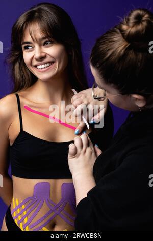 Kinesiologie-Taping. Kinesiologieband auf der Brust des Patienten. Junge Frau. Stockfoto