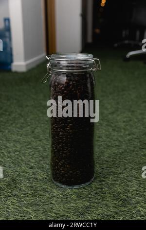 Großes Glas Glas mit Kaffee Samen auf weißem Hintergrund Stockfoto