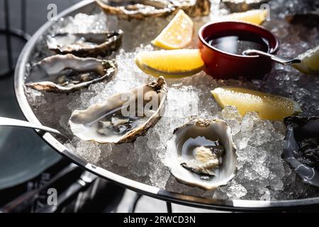 Austern auf Metalltablett mit Eis, Zitronenmenü, Diät, Kochbuchrezept Stockfoto