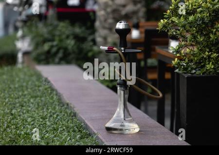 Shisha steht auf der Straße am Tisch. Raucherkonzept. Traditioneller Funken Stockfoto