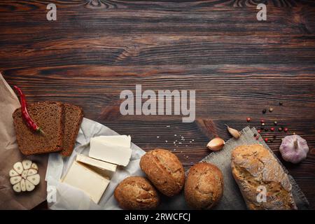 Ein Set Öl, Brot, Pfeffer, Knoblauch auf einem braunen Holzbrett Stockfoto