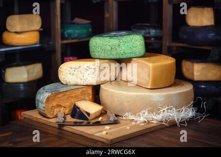 Käsescheiben, grün, Käseköpfe, verschiedene Arten, auf einer hölzernen Oberfläche Stockfoto