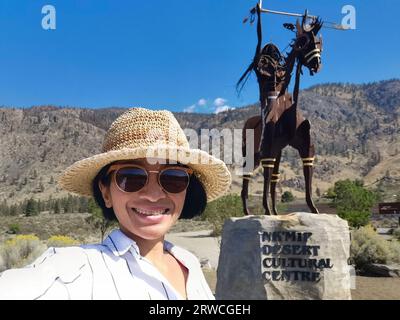 British Columbia, Kanada - 8. September 2023: Eine Touristenfrau nimmt Selfie vor der Hauptskulptur des NK'MIP Desert Cultural Centre in Osoyoos Stockfoto