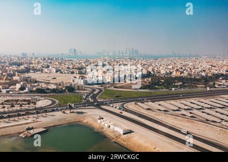 Eine Luftaufnahme des Township Muharraq in der Nähe des internationalen Flughafens Bahrain. Manama City kann man in der Entfernung über die Bucht sehen Stockfoto